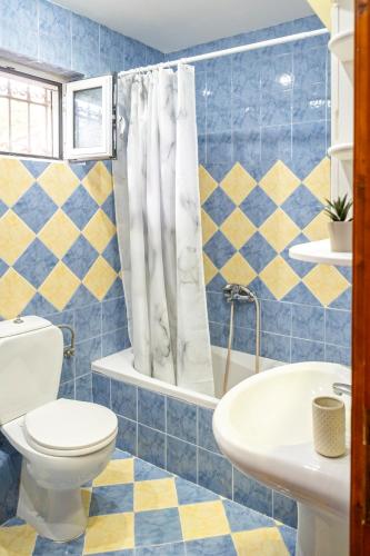 a blue and yellow bathroom with a toilet and sink at Castle House in Áno Yerakaríon