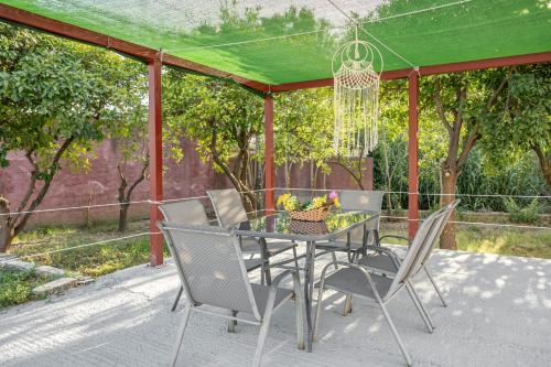 a table and chairs on a patio with a green canopy at Castle House in Áno Yerakaríon