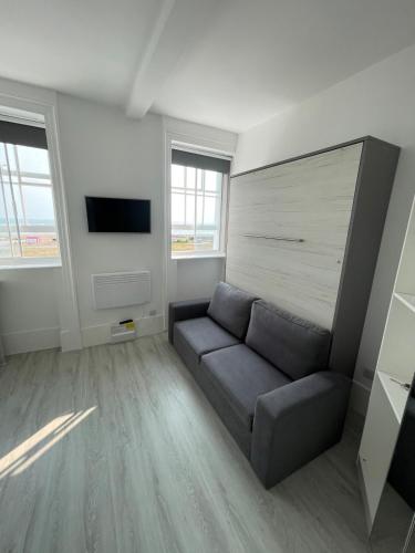 a living room with a couch and a tv at Seafront Studio Snug by the Sea - Sea Views in South Hayling