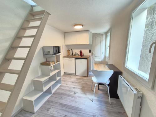 une cuisine avec un escalier, une table et une chaise dans l'établissement Le Saint Benoît #Confort, à Clermont-Ferrand