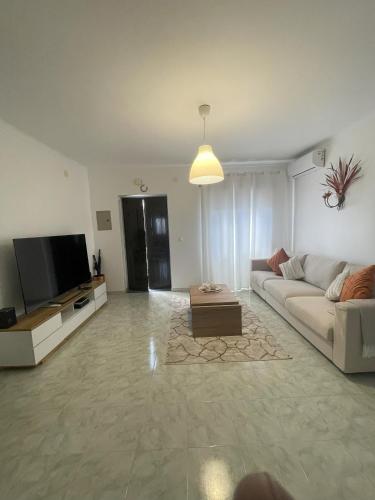 a living room with a couch and a flat screen tv at Casa da Aldeia in Moura