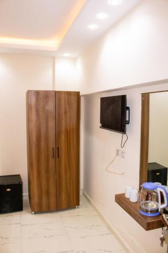 a room with a wooden cabinet and a tv on the wall at Pyramids sun set view in Cairo