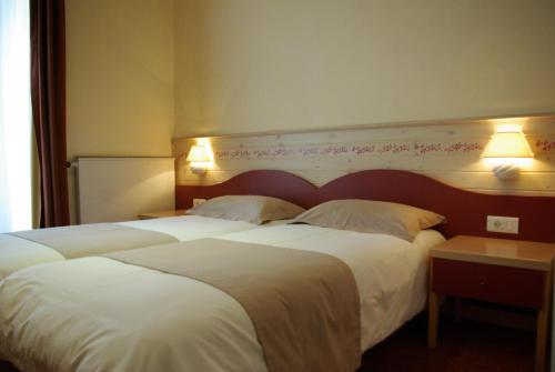 a hotel room with two beds and two lamps at Le Mirval in La Brigue