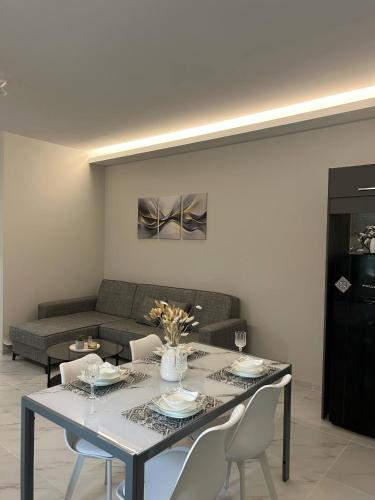 a living room with a table with chairs and a couch at Garden House in Kalamata