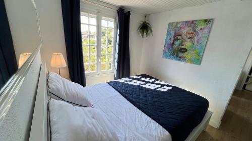 une chambre avec un lit et un tableau au mur dans l'établissement Villa with sea view and garden City centre and nature, à Roquebrune-Cap-Martin