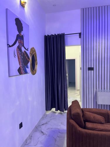 a living room with a couch and a picture on the wall at 1-Bed Modern Apartment in Ikeja, Lagos in Iseri
