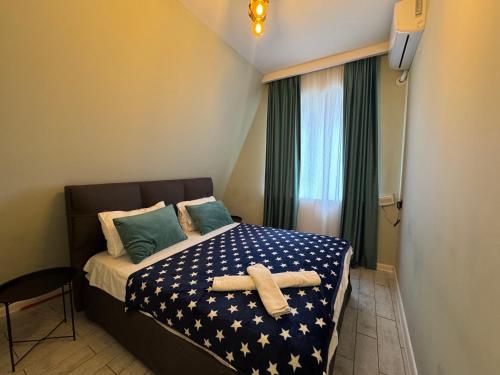 a small bedroom with a bed with a star patterned sheets at Qafqaz Suite Paradise Chalet & SPA in Gabala