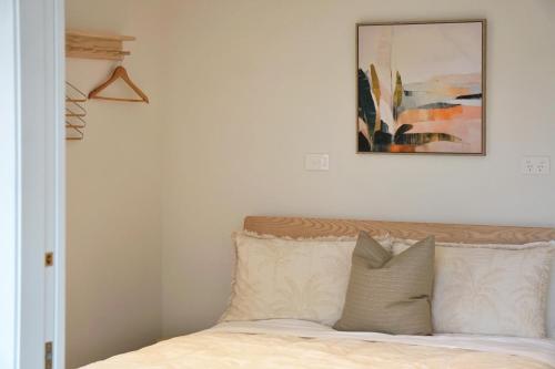a bedroom with a bed with a picture on the wall at Casa Karioi in Raglan