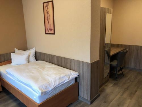 a small room with a bed and a chair at Katalin Motel & Étterem in Berettyóújfalu