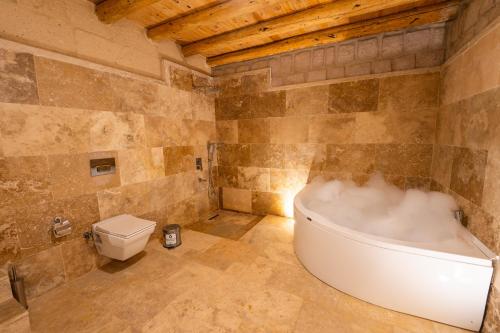 a bathroom with a bath tub and a toilet at Asyada Suites Hotel in Nevsehir