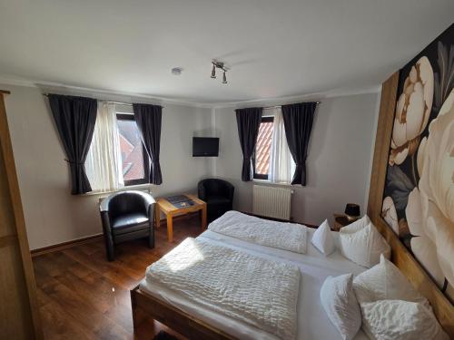 a bedroom with a bed and a desk and a chair at Pension ohne Frühstück in Gößweinstein