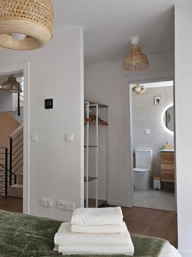 a bedroom with white walls and a bed with two white towels at L'adagio Olimpico by ARoom VUT-LE-1361 in León