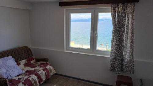 a bedroom with a window with a view of the ocean at Villa Shine apartment 2 in Radožda