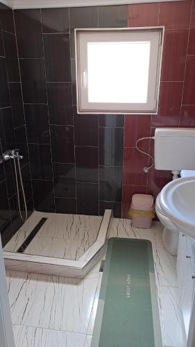 a bathroom with a shower and a toilet and a window at Villa Shine apartment 2 in Radožda