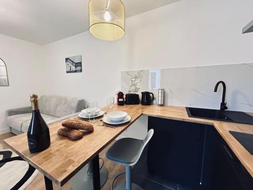 une cuisine avec un plan de travail en bois avec un évier et une table dans l'établissement 4 clairmarais T2 chic et cocooning proche centre, à Reims