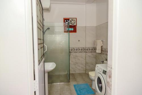Un baño con ducha, inodoro y lavabo. en Villa Kaluperuma, en Beruwala