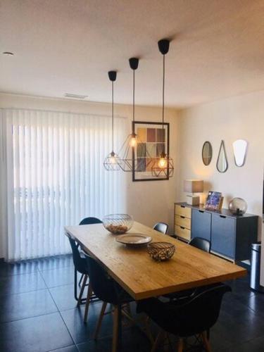 une salle à manger avec une table et des chaises en bois dans l'établissement Maison proche de Perpignan et de la mer, à Pia
