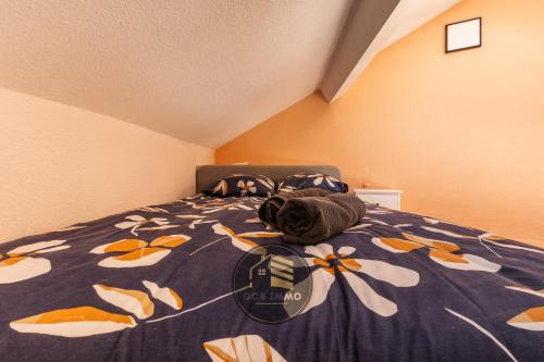 - un lit avec une couette bleue et des fleurs dans l'établissement Le Petit Saint Paul, à Grenoble