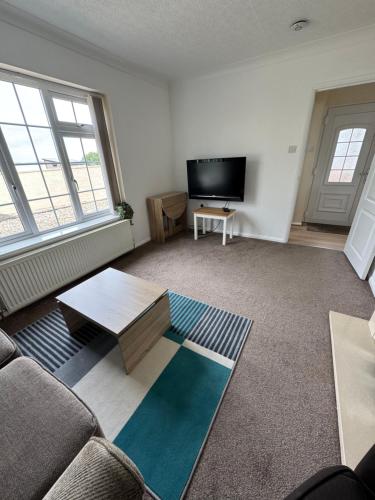 a living room with a couch and a tv at Primley View in Goodrington