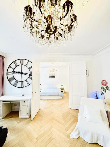 une chambre avec une grande horloge et un lustre dans l'établissement 3 pièces Orangerie-Centre, à Strasbourg