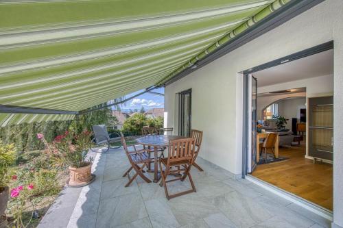 un patio avec une table et des chaises dessus dans l'établissement Villa de charme proche du lac, à Sciez