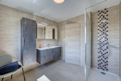 une salle de bain avec une douche en verre et un lavabo dans l'établissement Villa de charme proche du lac, à Sciez