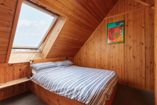 a bed in a wooden room with a window at Capsule Rooms, FREE PRIVATE PARKING in Whitby