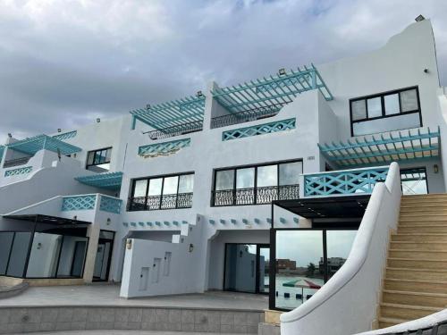 a large white building with stairs in front of it at شاليهات درة العروس برادايس لاقون سلسبيل عائلات فقط in Jeddah