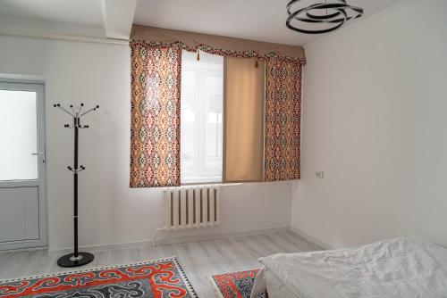 a bedroom with a window and a rug at Sunny Valley Guest House Karakol in Karakol
