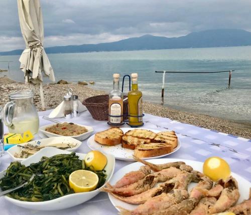 a table with plates of food and a view of the ocean at SeaTerra Boutique suite in Kalamos