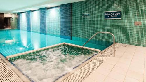 a swimming pool with a hot tub in a building at Oaks Glenelg Balcony Apartment in Glenelg