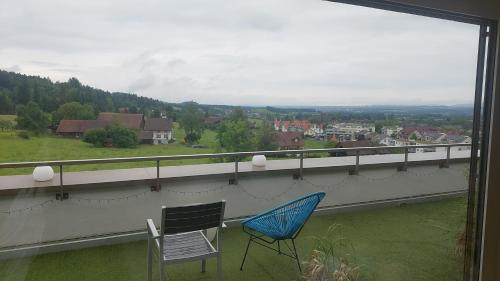 two chairs sitting on a balcony with a view at Helles WG Zimmer 1von4 in fantastischer Attikawohnung in Oetwil am See