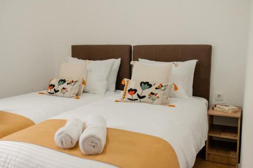 two beds with white sheets and pillows at Villa Petra in Ohrid