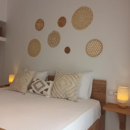 a bedroom with a bed with white sheets and pillows at Maison Kalogiannis in Patitiri