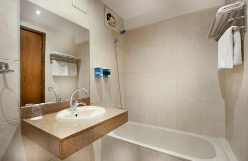 a bathroom with a sink and a bath tub at Kanzy Hotel Cairo in Cairo