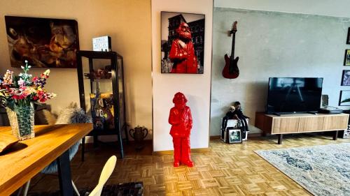 a red figurine standing in a room with a tv at Domus Merian XII in Trier
