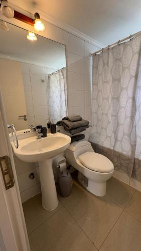 a bathroom with a sink and a toilet and a mirror at Lindo departamento vista Club de golf Santo domingo, cerca de parque Tricao in Santo Domingo