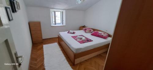 a small bedroom with a bed with pink pillows at Downtown Dream Makarska in Makarska