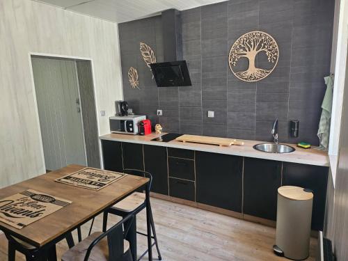 une cuisine avec une table, un évier et un comptoir dans l'établissement Balneo détente, à Baume-les-Dames