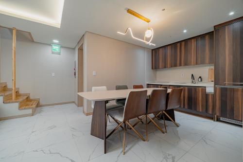 a kitchen and dining room with a table and chairs at Masion Sanbang Jeju in Seogwipo