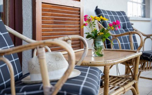 a table and chairs with a vase of flowers on it at Flo's Ferienwohnungen in Zeil