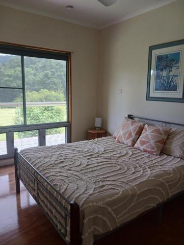 a bedroom with a bed and a large window at Mission Beach Rural Escape in Mission Beach