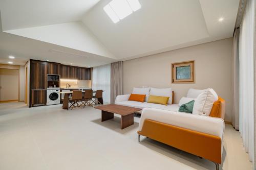 a living room with a couch and a table at Masion Sanbang Jeju in Seogwipo