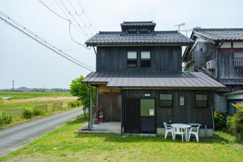 a house with a table and chairs in front of it at ホタル屋 in Takashima