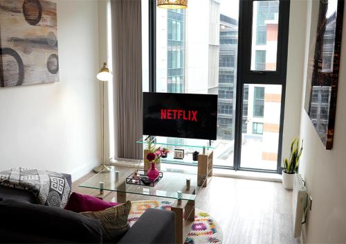 a living room with a tv and a couch at Stylish & Cosy Central Bham Apt in Birmingham