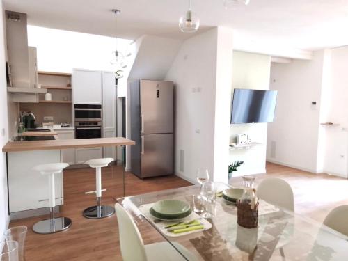 a kitchen with a glass table and a stainless steel refrigerator at Civico 381 - private parking in Quartu SantʼElena