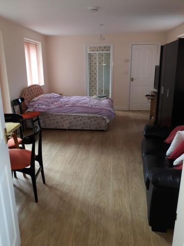 a bedroom with a bed and a table and a couch at Garden Cottage in Stone