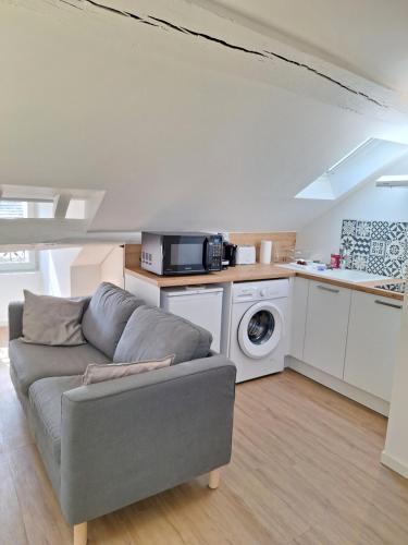 un salon avec un canapé et une cuisine dans l'établissement Notre Dame 6 - Duplex 4 personnes - Hypercentre, à Orléans