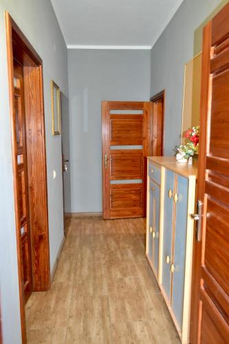 an empty room with a kitchen with wooden doors at Noclegi Bero Fejn in Lipusz