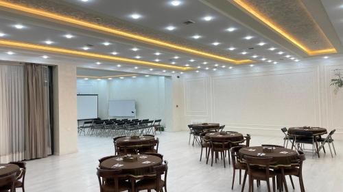 a room with tables and chairs and a projection screen at Chinor Hotel Fergana in Fergana